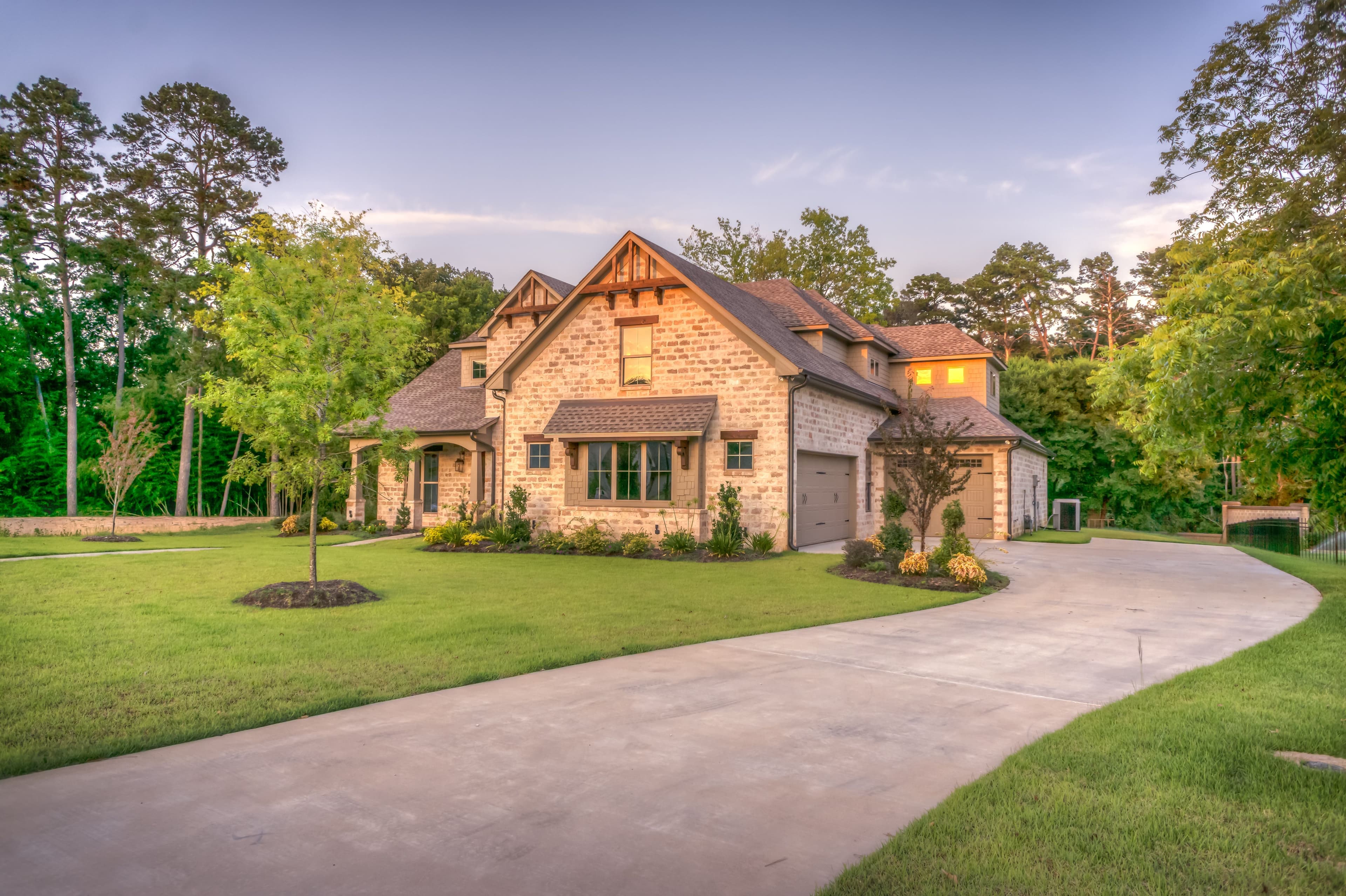 A large home with a landscaped lawn and driveway